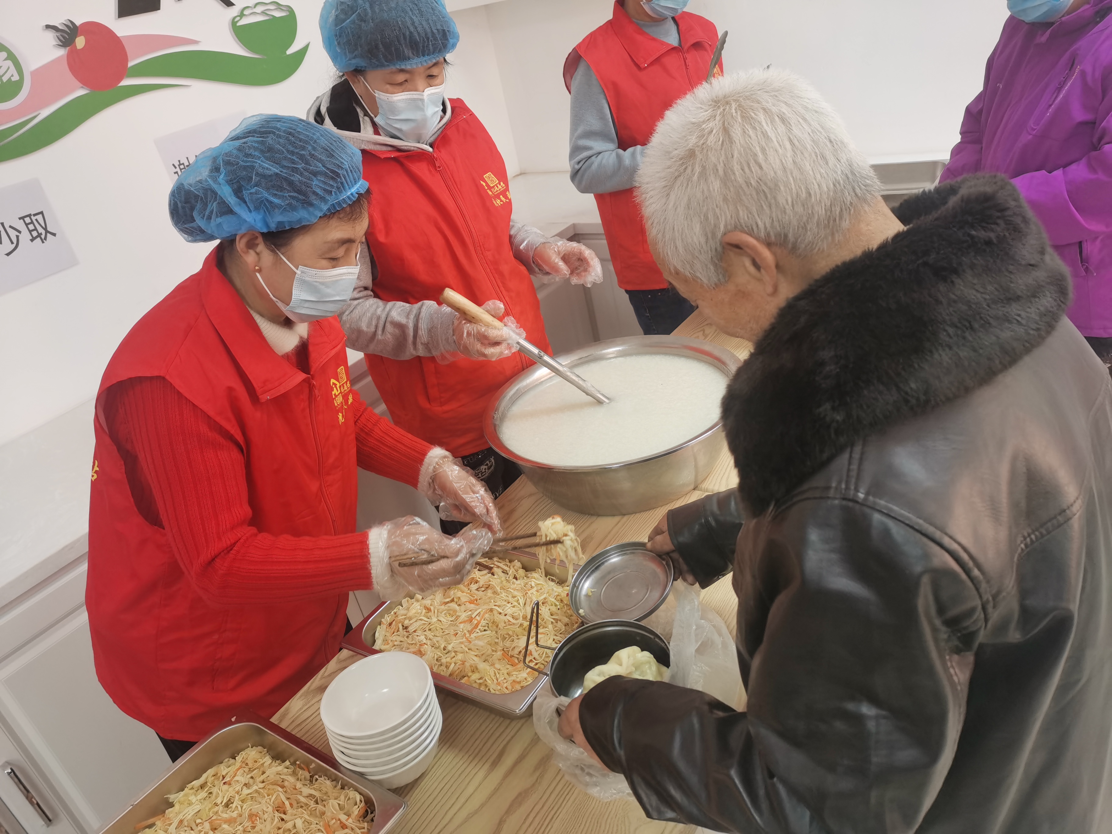 图二:颇家屯村幸福长者食堂工作人员为老人打饭.jpg 雪缘园